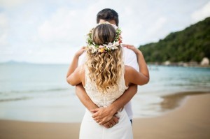 Casal na praia, de frente um para o outro, tirando fotos pré-wedding.