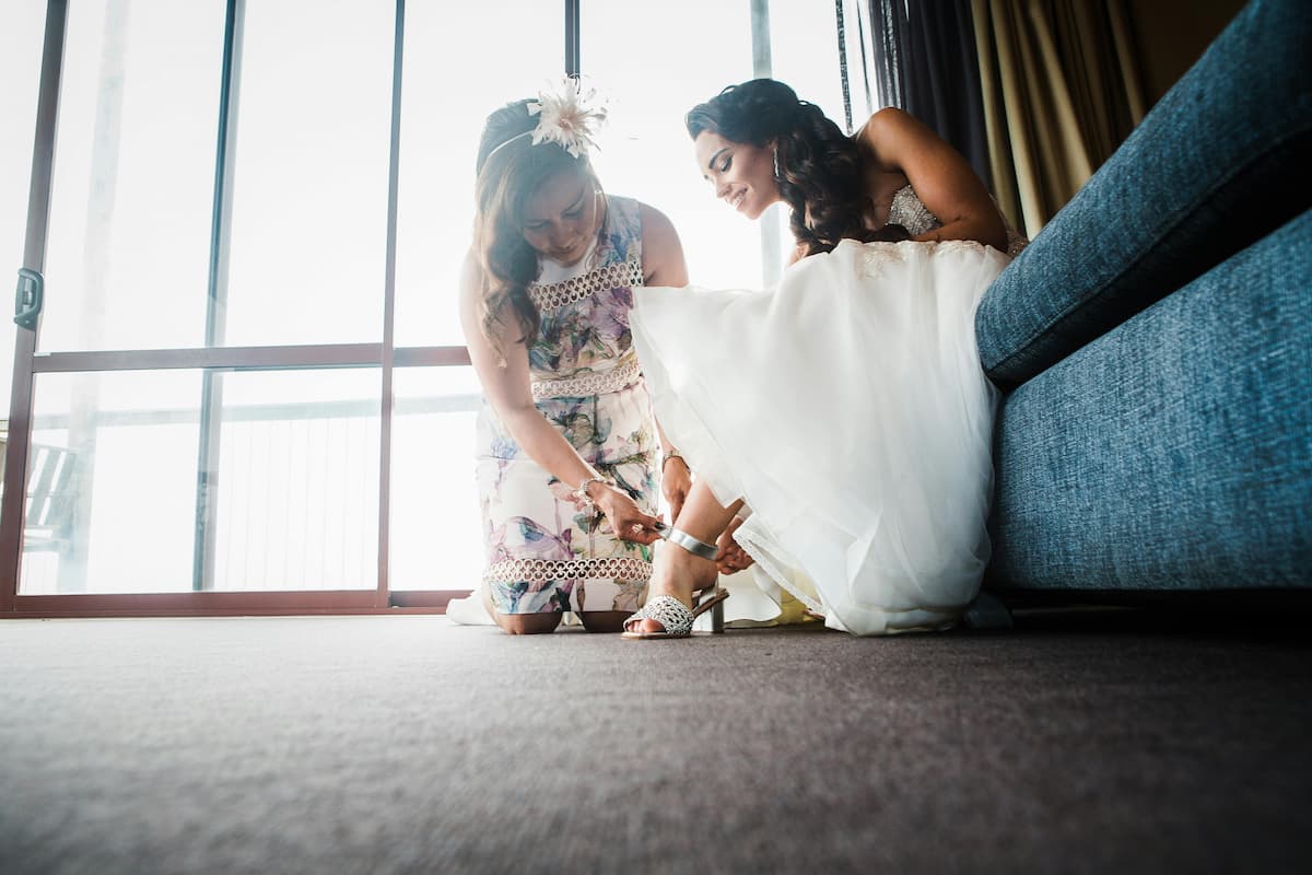 Uma noiva sentada tirando seu sapato