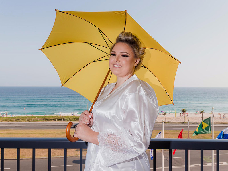 Casamento no campo noiva de robe na varando com guarda-chuva amarelo