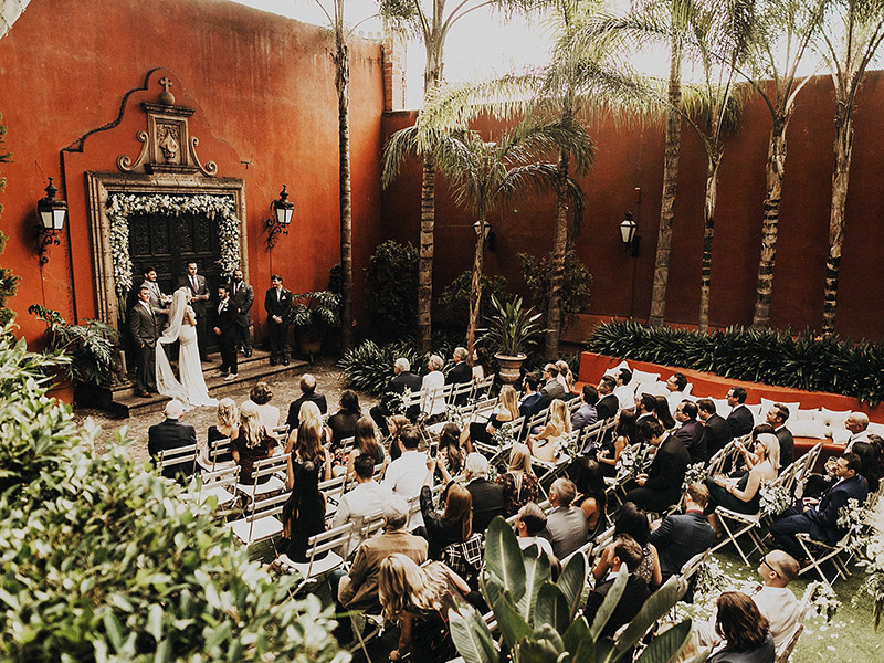 imagem de celebração de casamento em um local aberto repleto de palmeiras