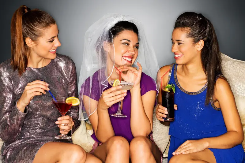 Três mulheres celebram em despedida de noivado. 