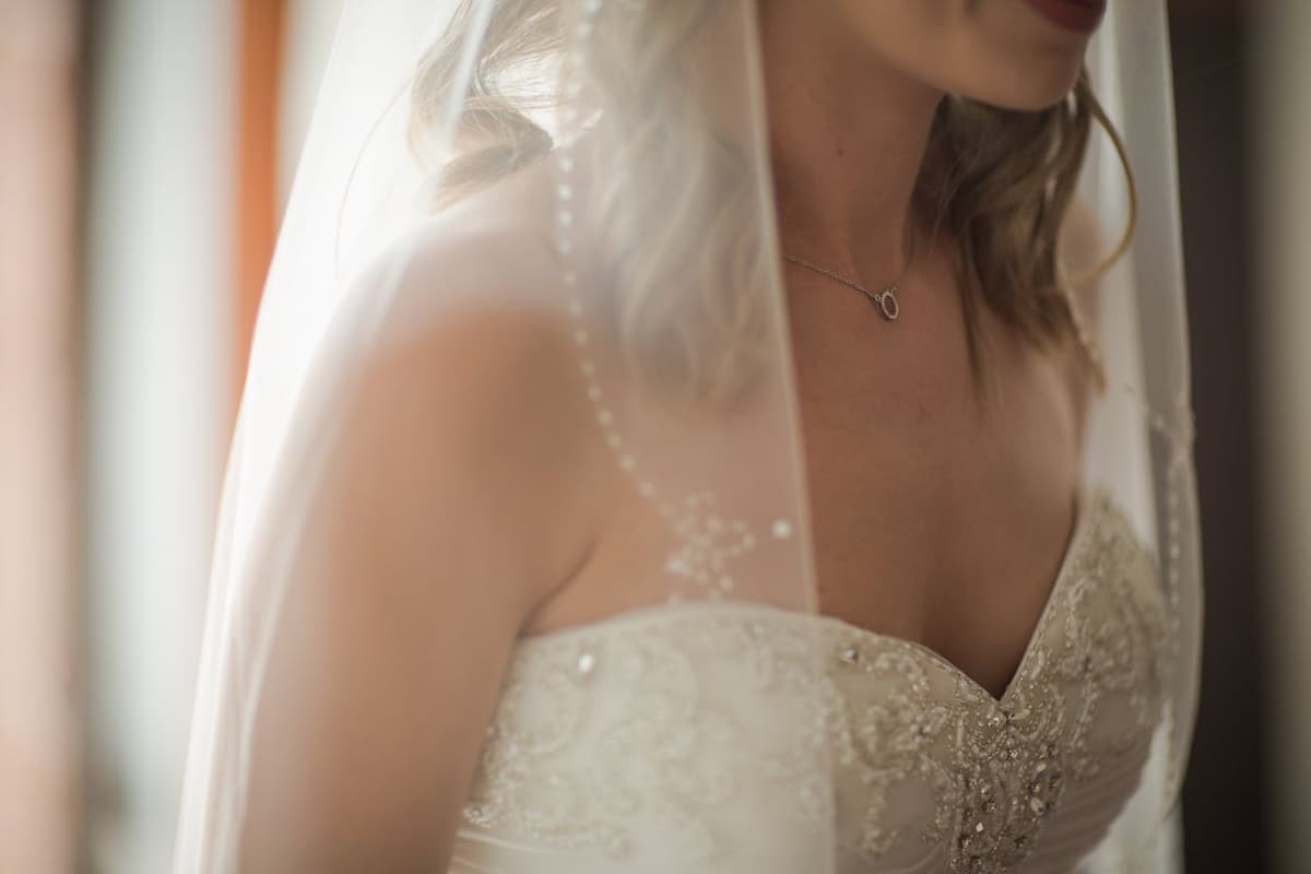 Imagem do pescoço e colo de uma mulher com o vestido de noiva