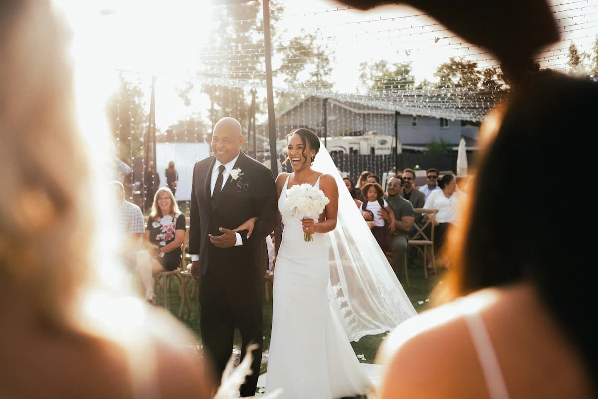 Imagem de uma noiva entrando com o pai no dia do casamento
