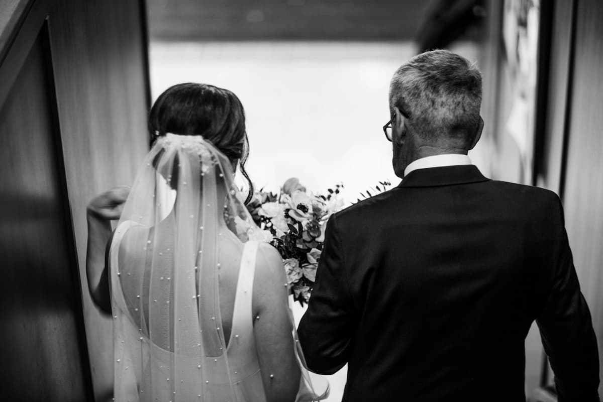 Imagem de uma noiva com o seu pai chegando no local de casamento
