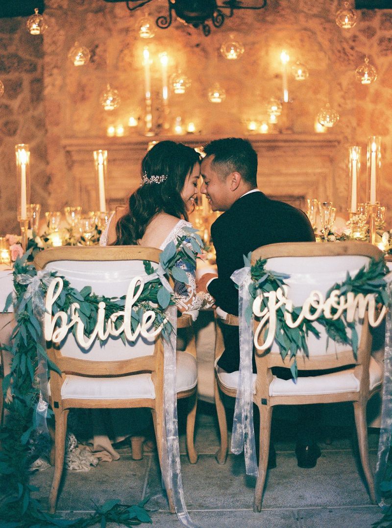 Casal de noivo e noiva se beijando em um local com decoração de casamento romântica