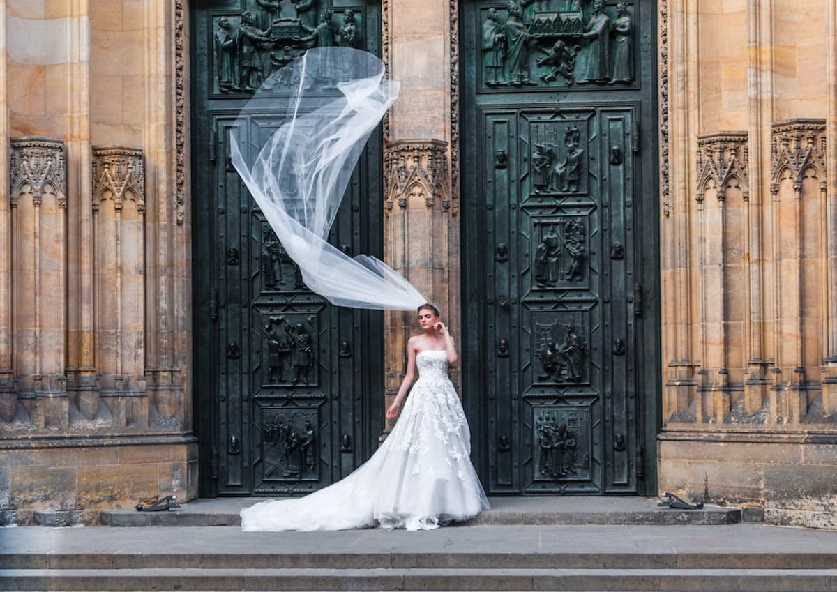 Imagem de uma noiva na frente de um lugar com grandes portas fechadas