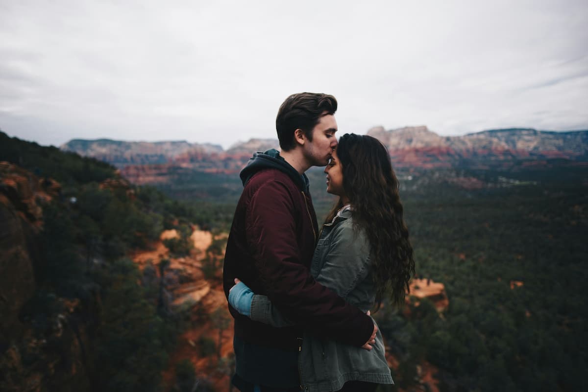 Imagem de um casal abraçados no topo da montanha