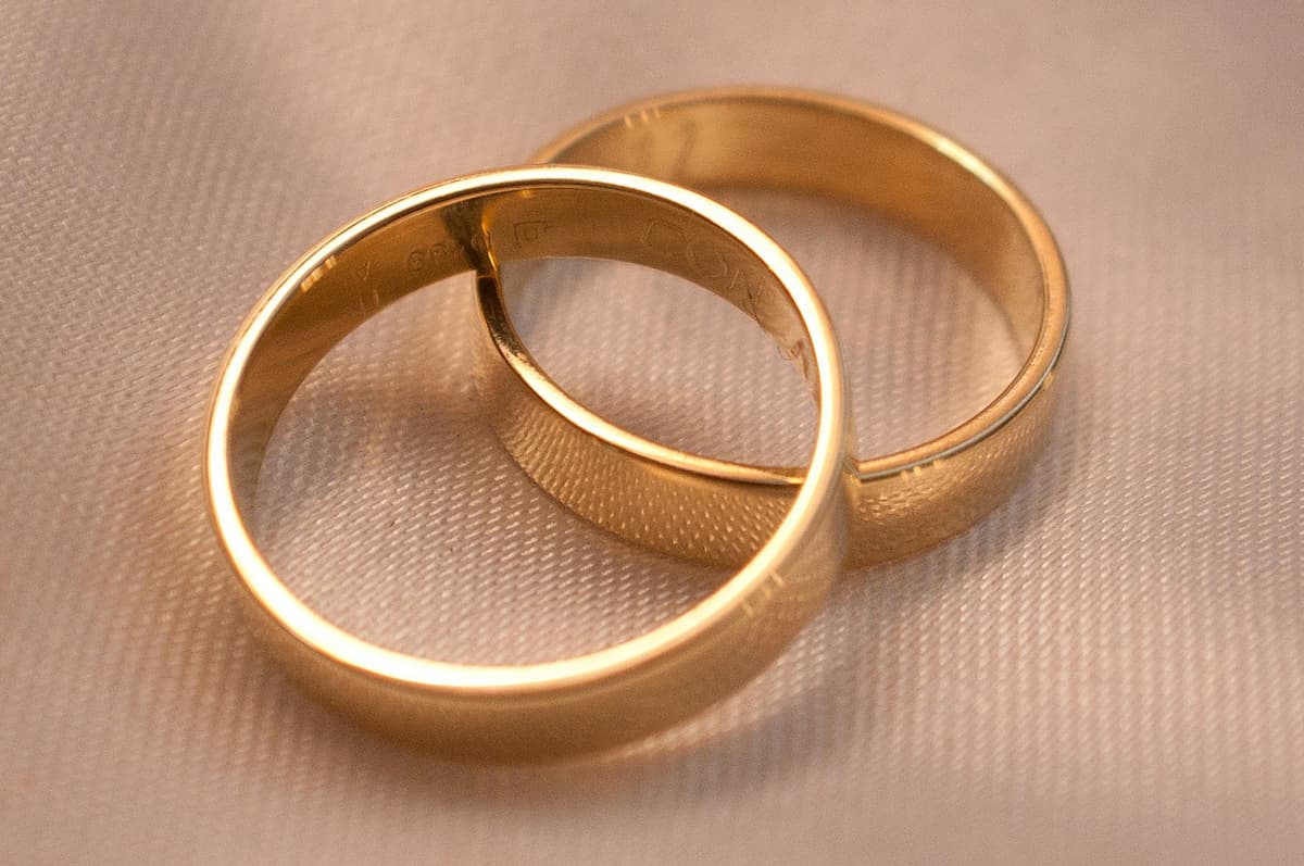 Imagem de dois anéis dourados em um fundo rosa