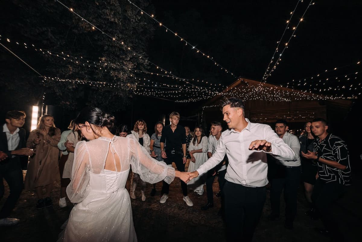 Imagem de um casal dançando na festa de casamento com os convidados