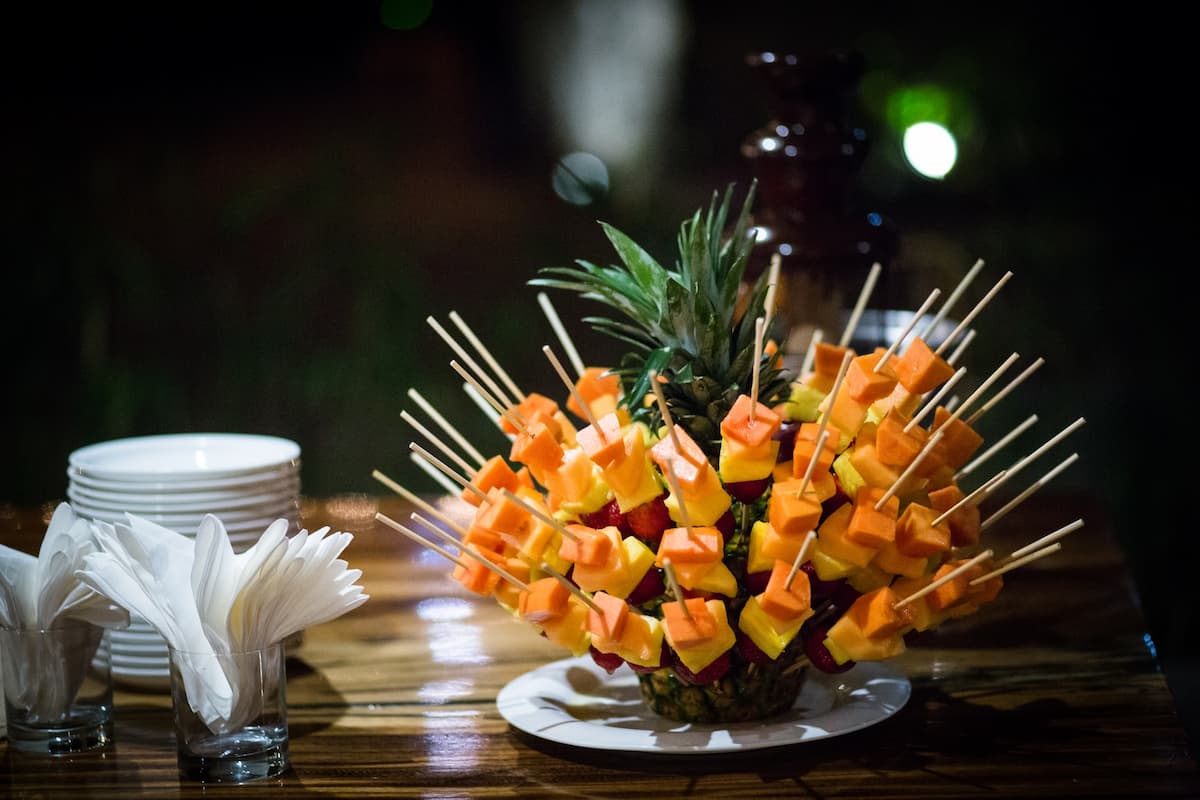 Imagem de frutas em espetinhos formando um buquê de flores