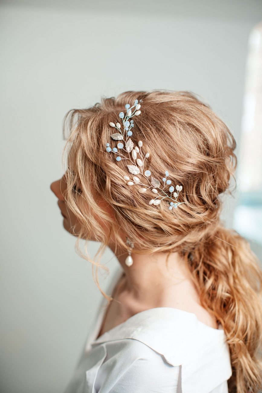 Noiva de perfil exibindo uma presilha branca no cabelo. Imagem disponível em Pexels.