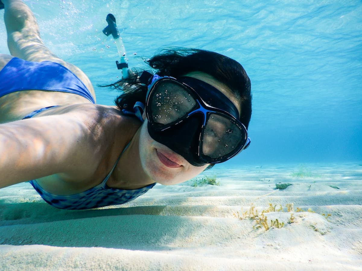 Mulher de óculos de mergulho em baixo d'água