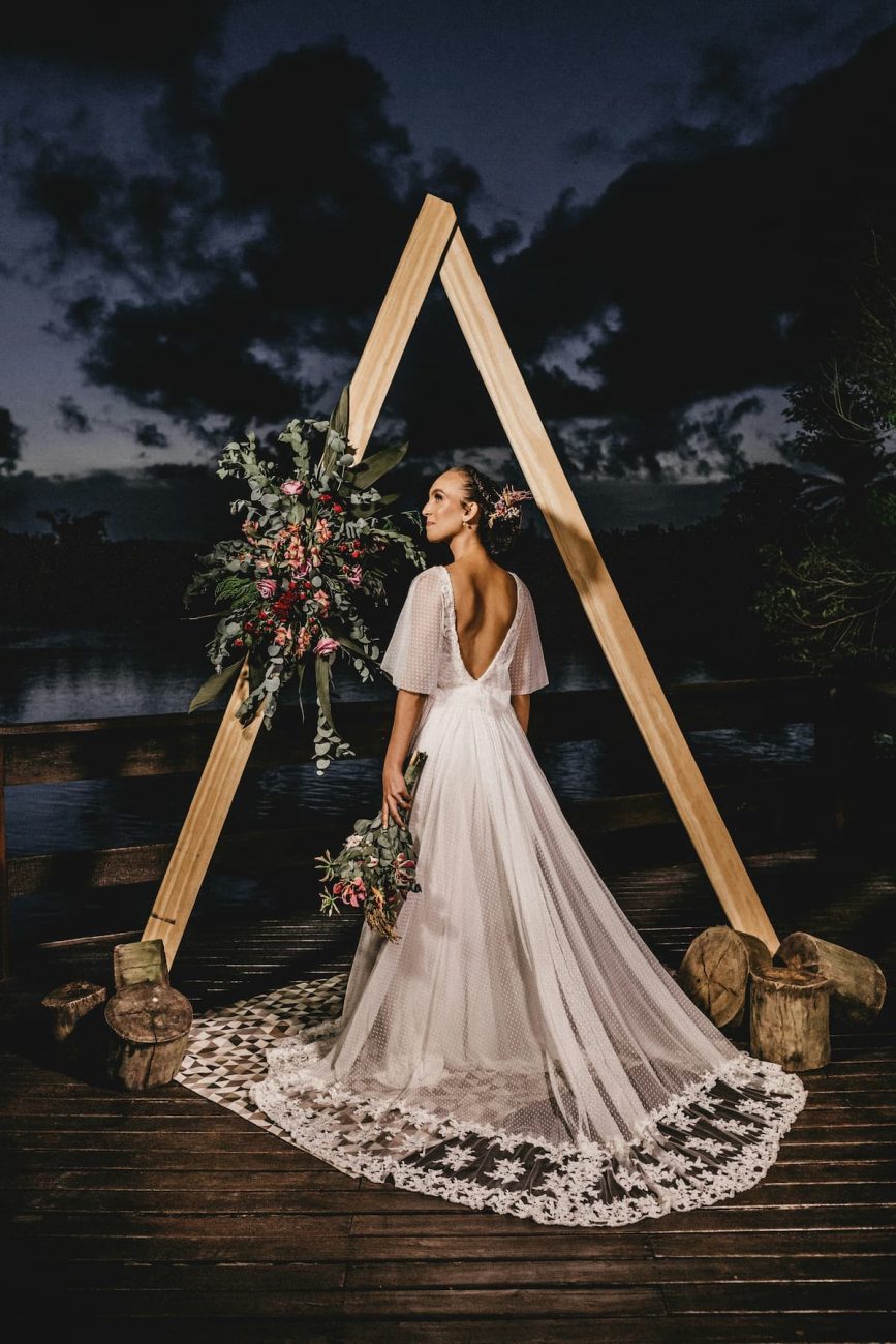 Uma noiva usando um vestido Corte Évasé e ao fundo um lago 