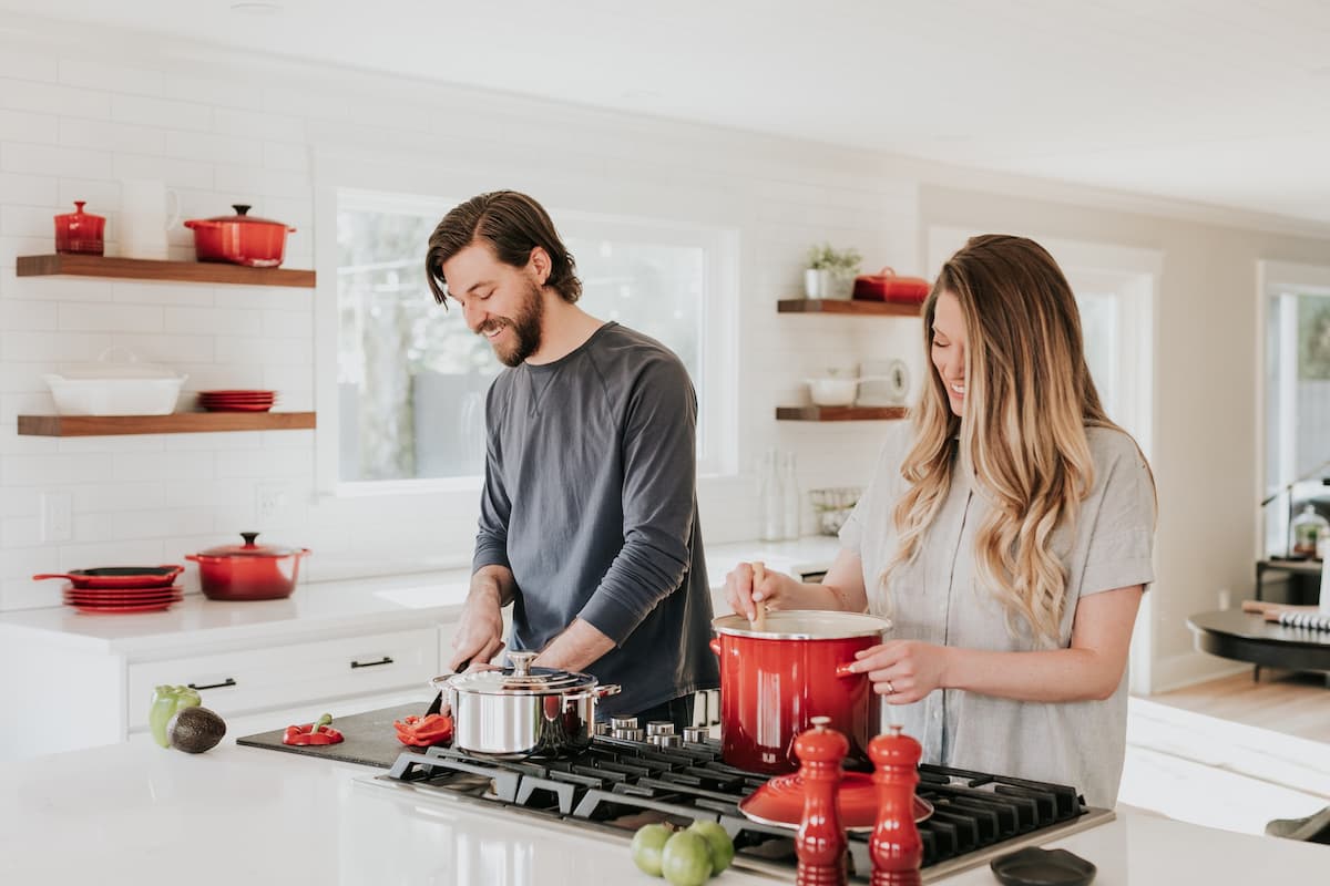 Imagem de um casal na cozinha cozinhando juntos