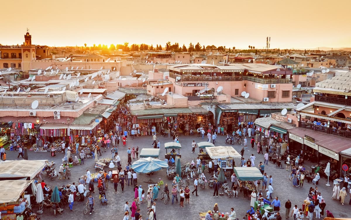 Pessoas andando durante o dia em um grande comércio em Marrakech