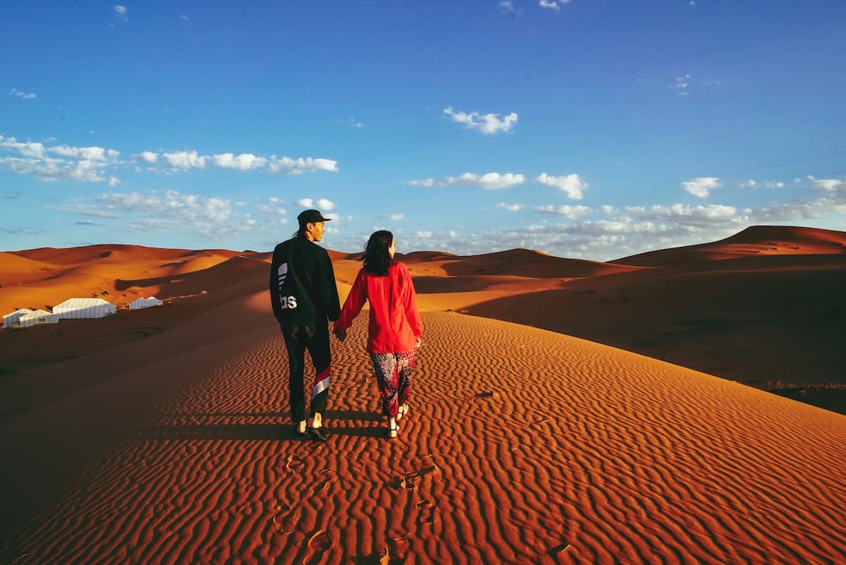 Homem e mulher andando no deserto durante o dia