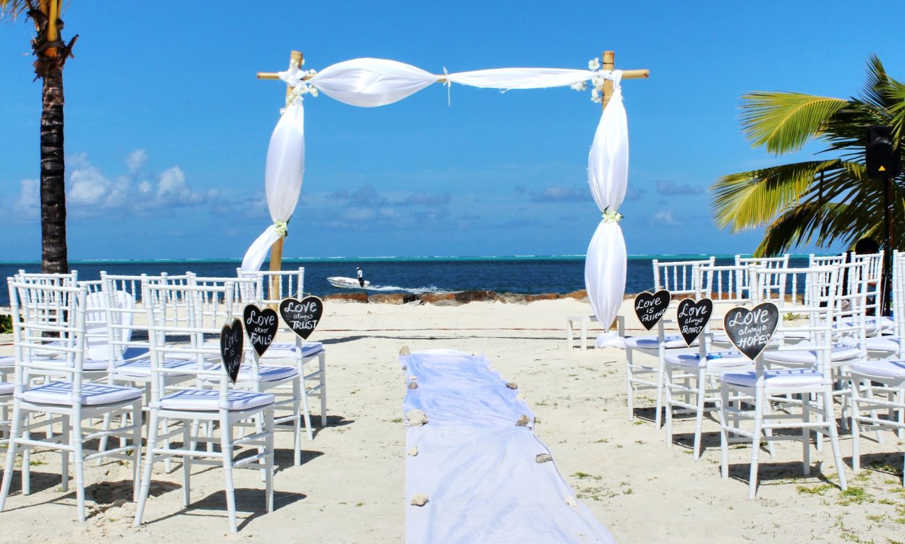 Camento Temático na Praia: imagem de um casamento na praia, de frente para o mar, com uma decoração branca e cadeiras vazias