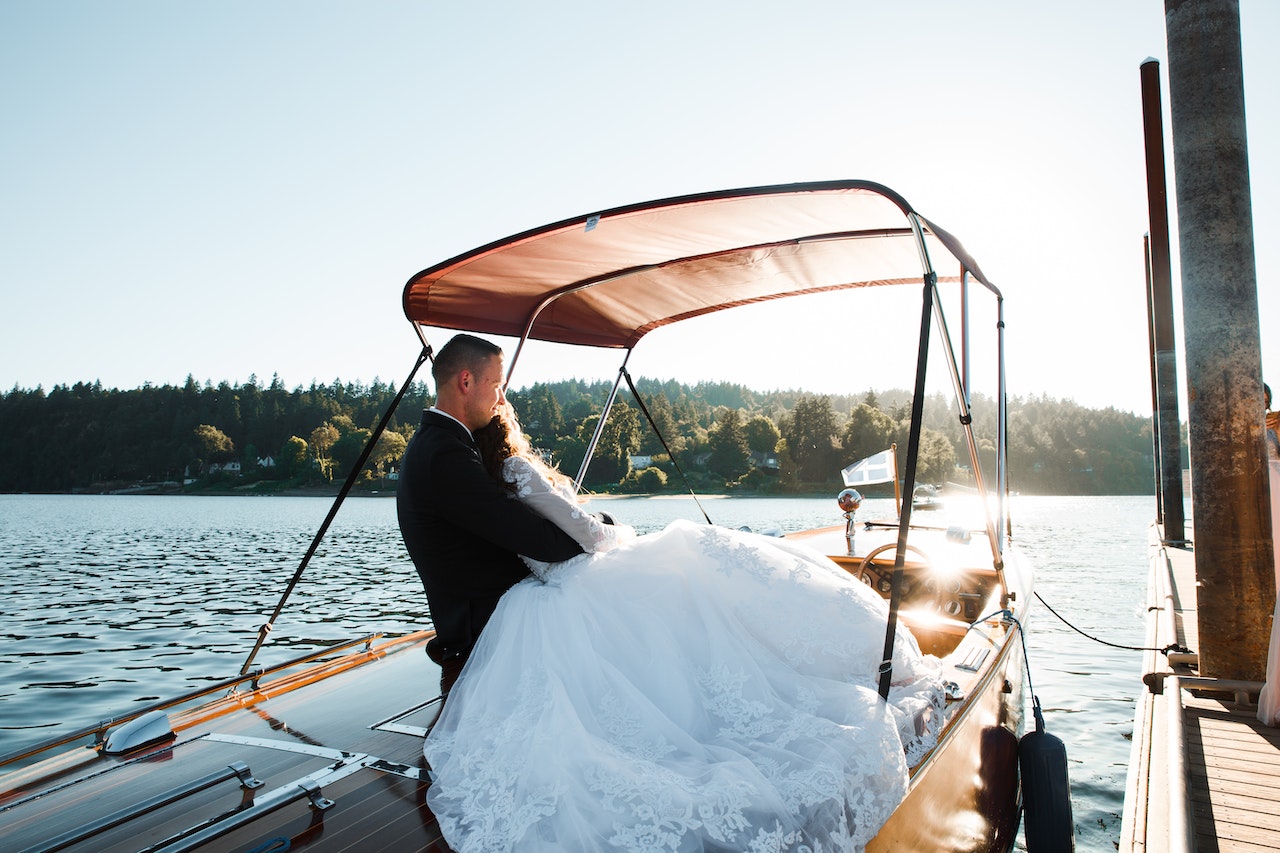 Casamento Temático Cultural: imagem de um casal de noivos dentro de um barco, em dia de sol