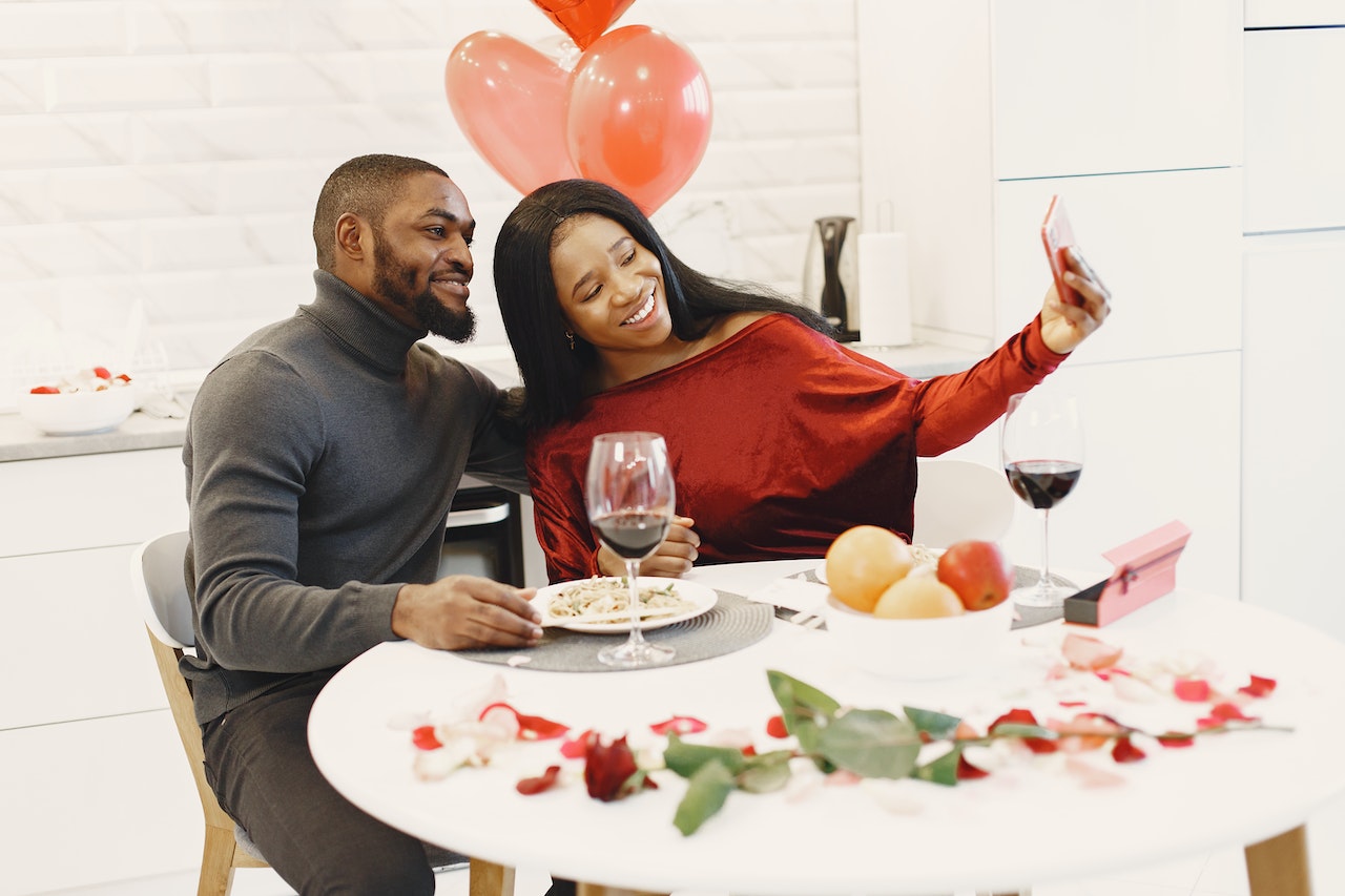 Casal sentado na mesa com itens decorativos românticos