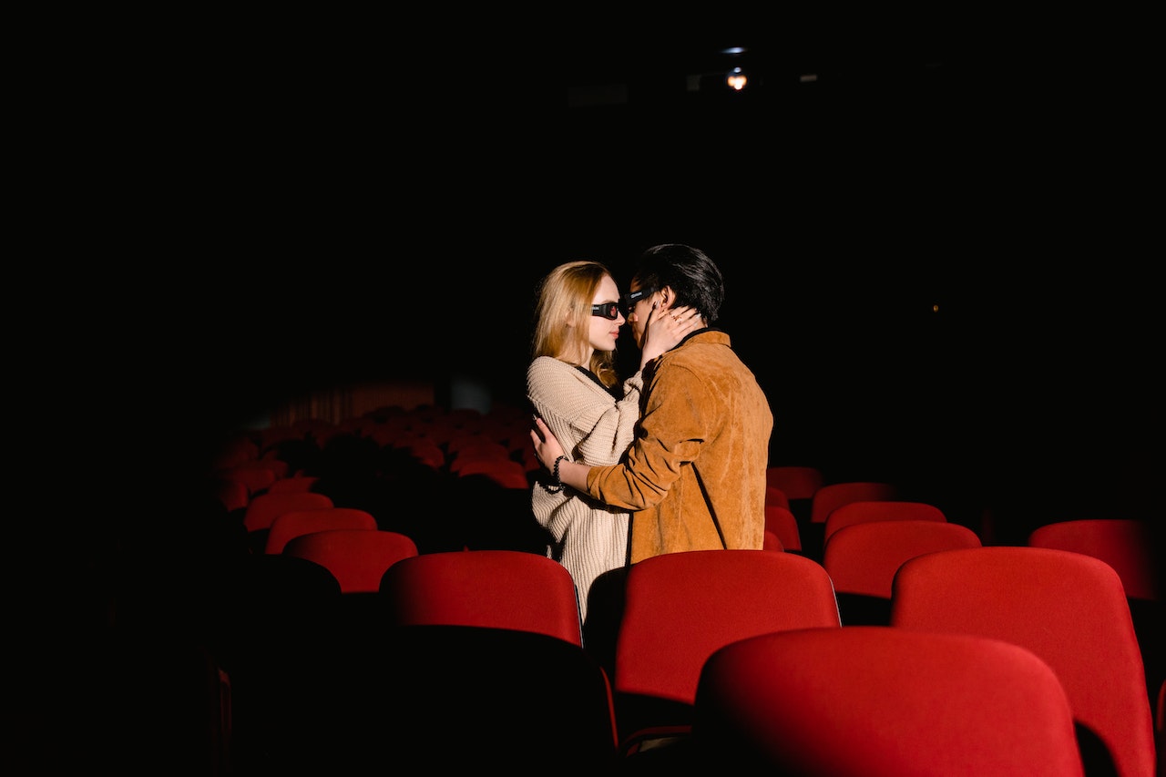 Casal se beijando em uma sala de cinema