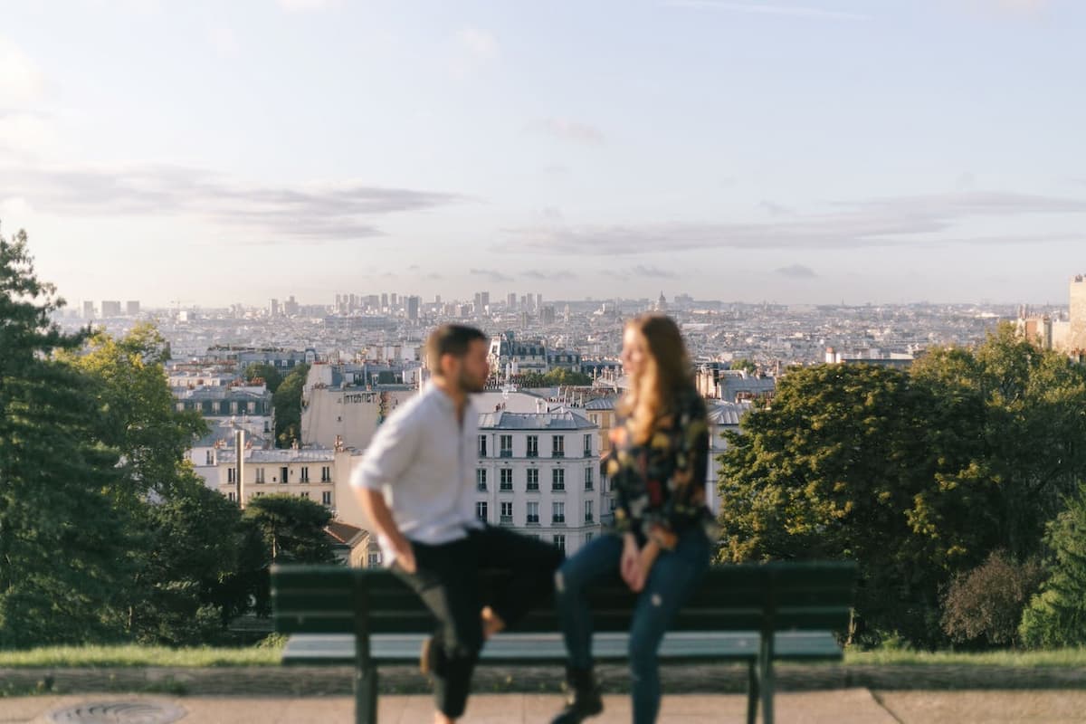 Imagem de um casal sentado em um banco em Paris