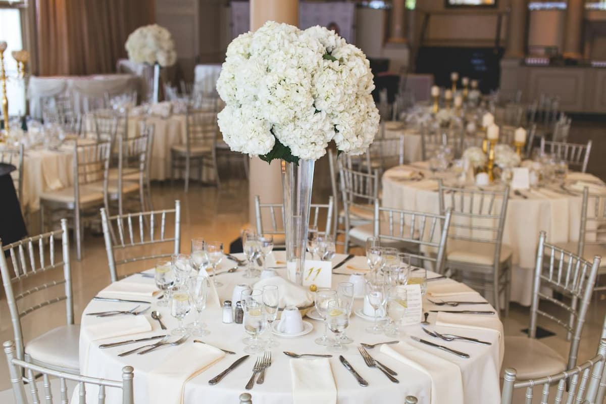 Imagem de uma mesa de casamento com decoração branca