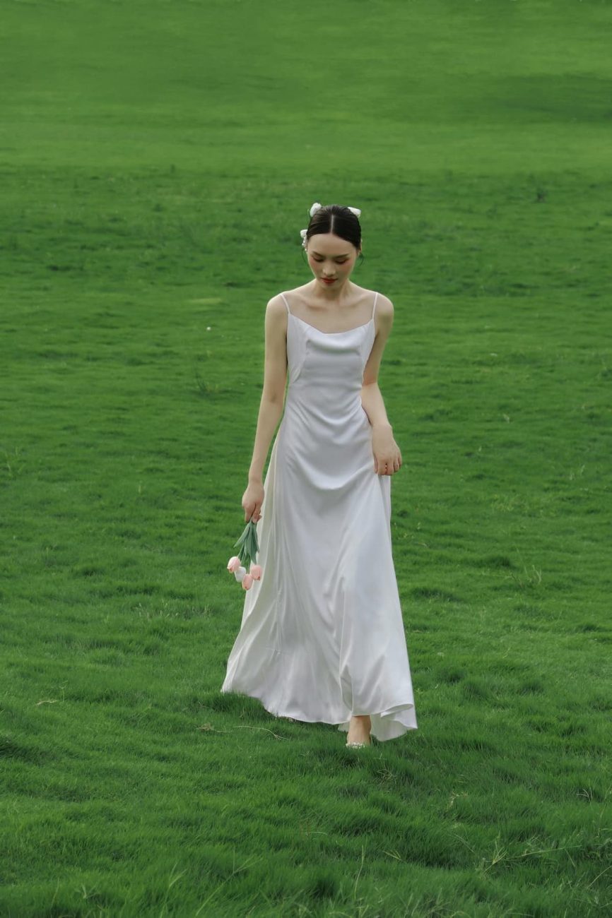 Imagem de uma mulher em um lugar ao ar livre usando um vestido de noiva branco simples