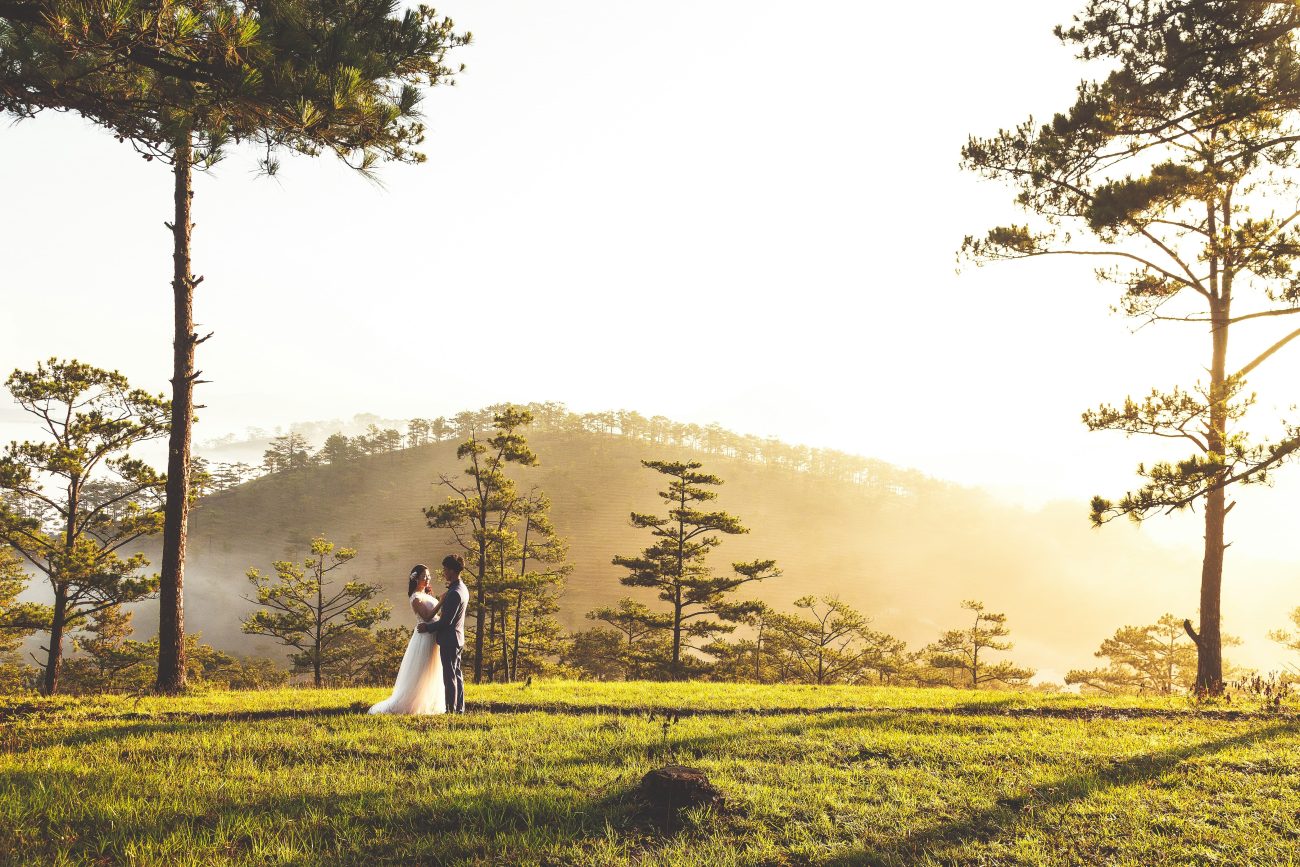 Casal de noivos posa para foto em cenário bucólico na montanha