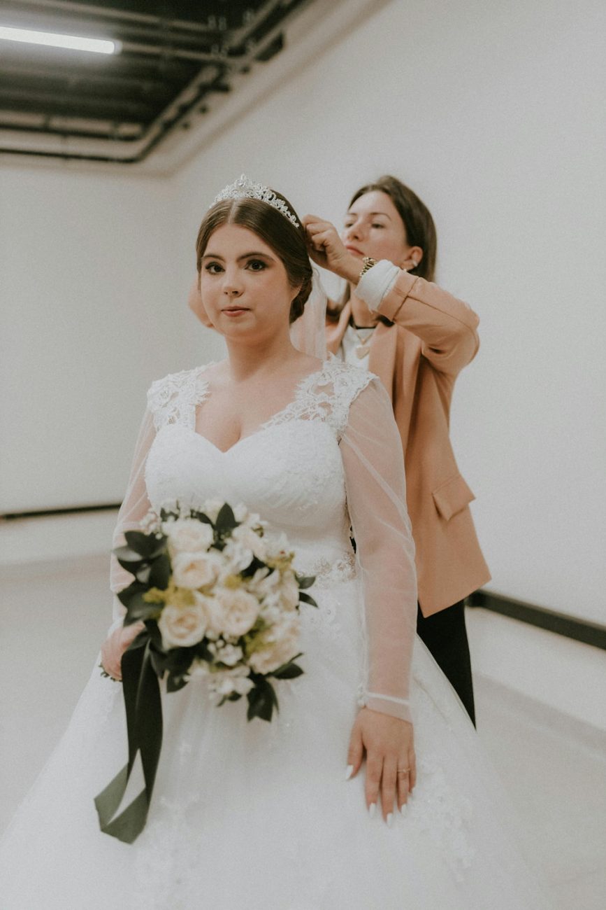 Assessora de casamento colocando o véu na noiva.