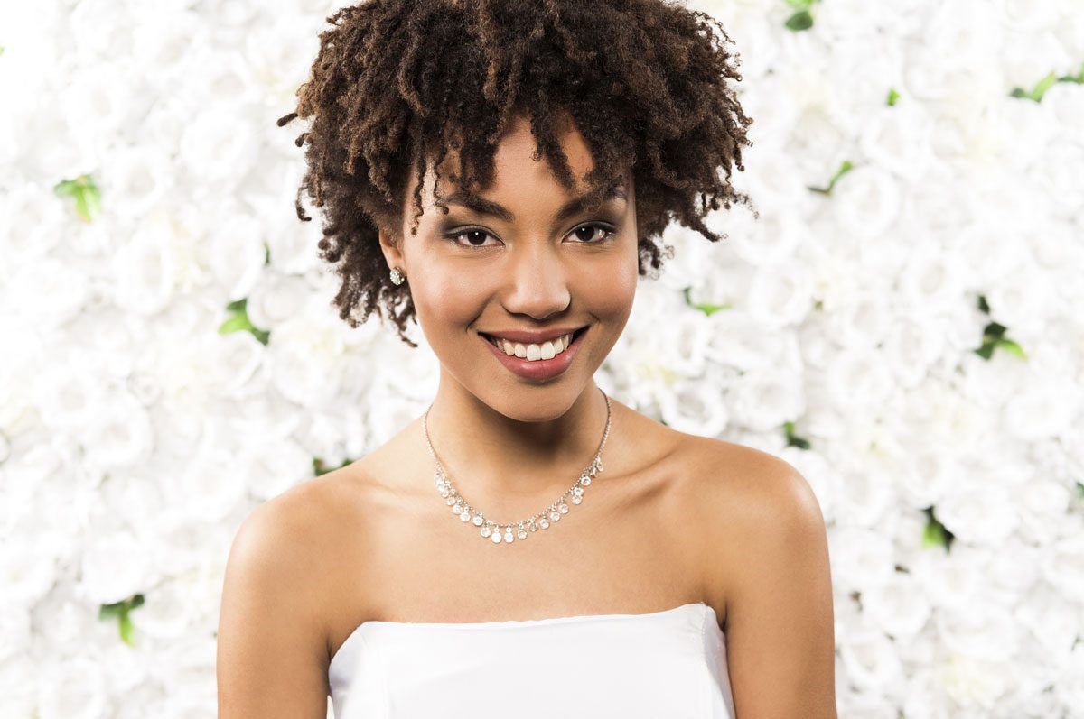 Penteado para cabelo cacheado no casamento com volume e acessório