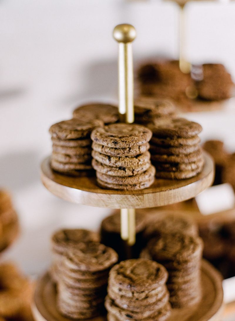 Cookies e bombons dispostos em suportes de vidro na mesa de doces para casamento