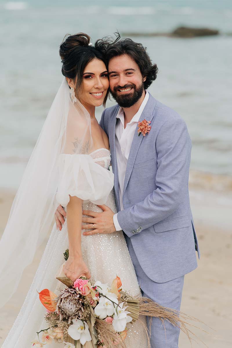 Retrato dos noivos durante o pôr do sol na praia