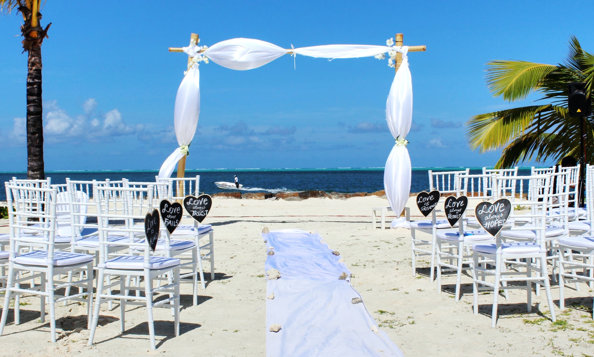 Camento Temático na Praia: imagem de um casamento na praia, de frente para o mar, com uma decoração branca e cadeiras vazias