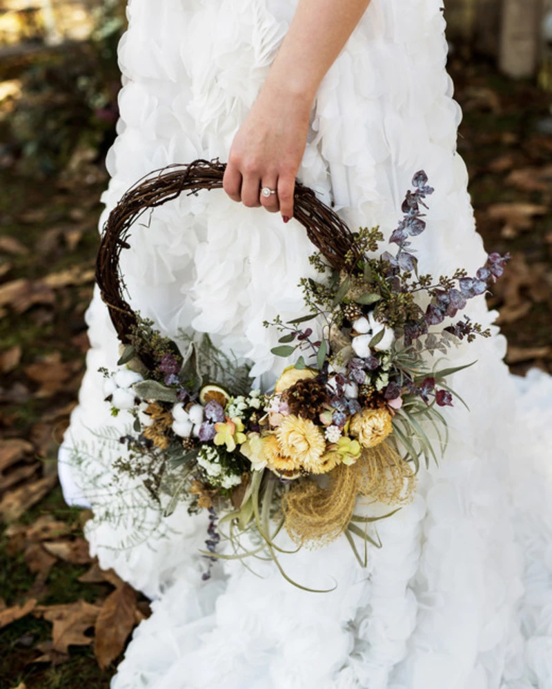 Buquê de noiva em arco minimalista com folhagens e uma flor grande