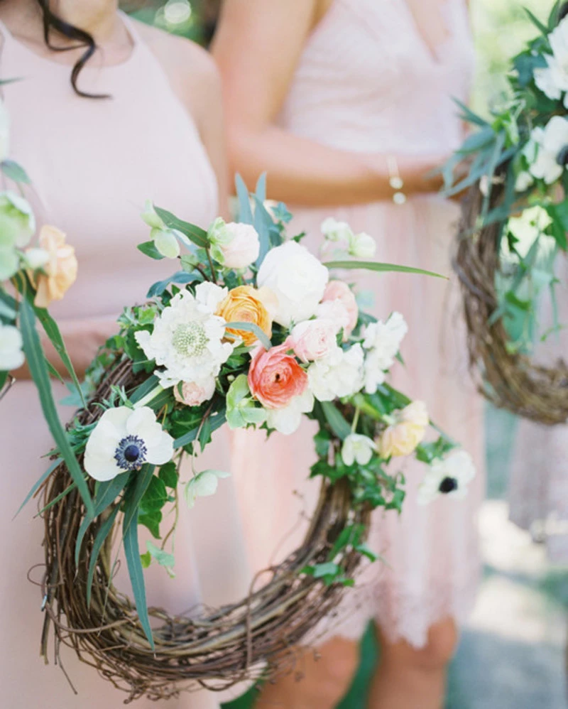 Buquê de noiva em arco com flores em tons de pêssego e folhagens leves