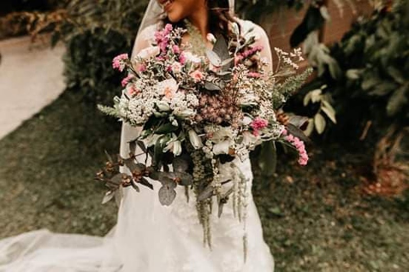 Buquê de noiva diferenciado com flores coloridas e sementes em cascata, ideal para casamento no campo
