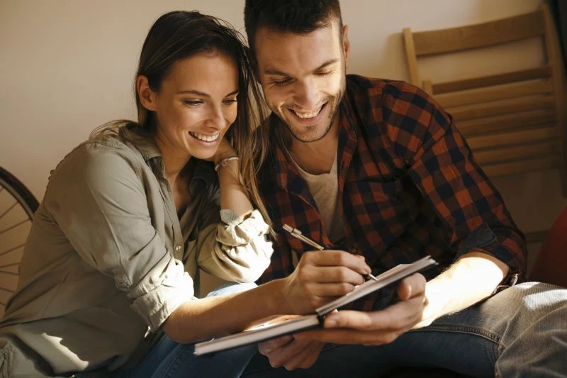|Homem escrevendo no caderno em uma mesa. Foto: iStock|||convite-de-casamento-modelos-de-2018-aquarela|frases-para-convite-de-casamento-2|50 frases para convite de casamento