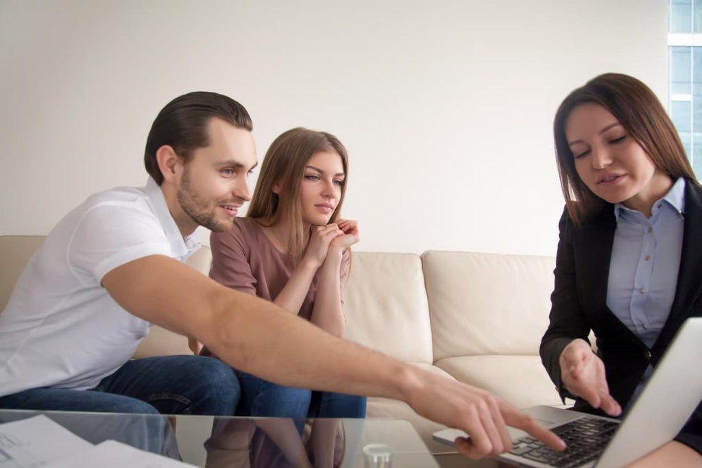 |Pessoa sentada à mesa assinando um documento em uma prancheta