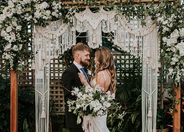|cerimônia-com-backdrop-de-macramê|trabalho-de-macramê-em-buquê|backdrop-de-cerimônia|cerimônia-com-backdrop-de-macramê|trabalho-de-macramê-em-cadeiras|decoração-aérea-com-macramê|bolo-de-casamento-com-macramê|buquê-em-arco-para-madrinhas|macramê-colorido|backdrop de cerimônia