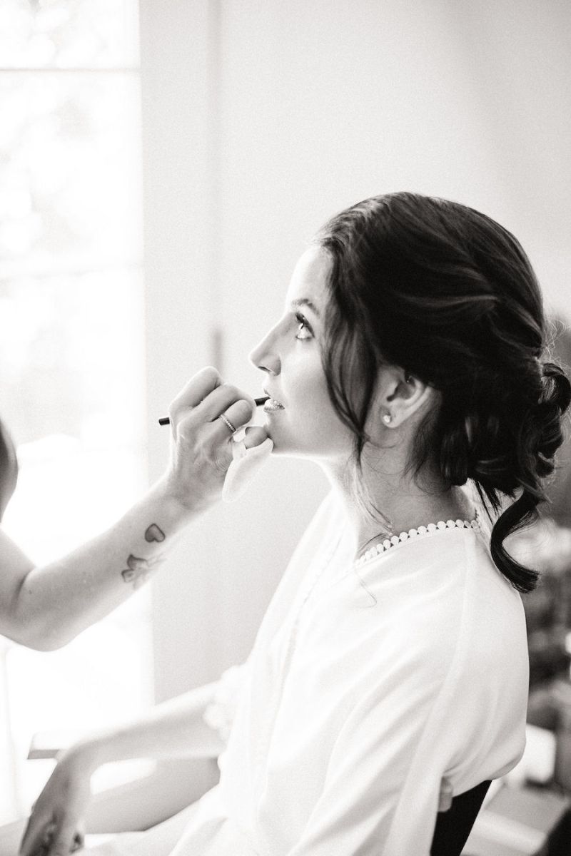 Noiva com maquiagem para noiva à noite com delineado clássico e batom vermelho, demonstrando um look atemporal