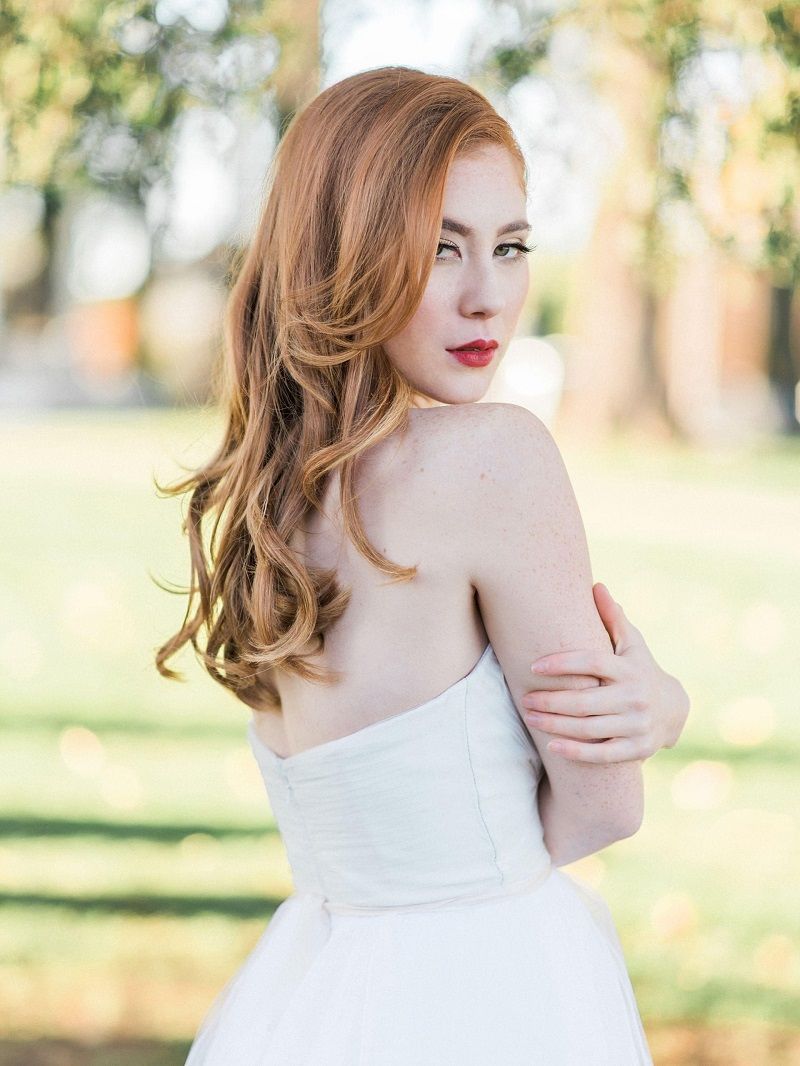 Maquiagem suave e iluminada para noiva ruiva com flores no cabelo