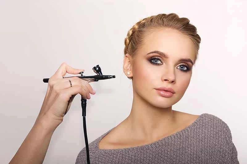 Maquiagem airbrush para noivas em pele morena com batom nude e acessórios no cabelo