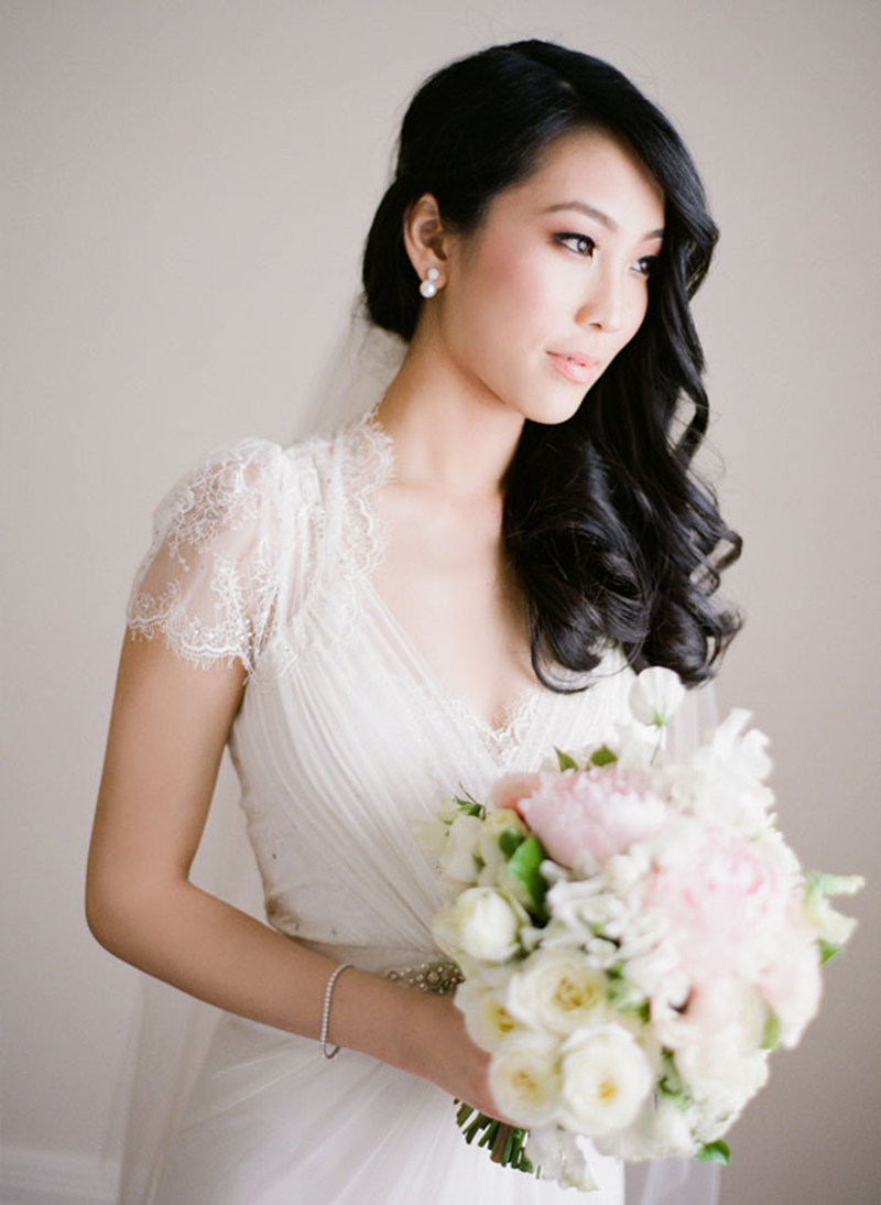 Close-up de noiva oriental com maquiagem neutra, lábios rosados e cabelo semi-preso.