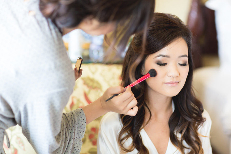 Noiva oriental com maquiagem clássica, batom vermelho e coque baixo.