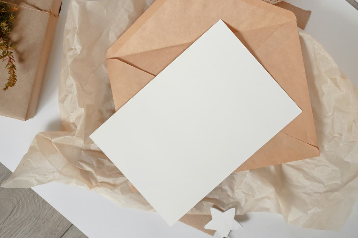 Um envelope de casamento|Um papel com caneta e lápis|Um cartão de envelope com o papel fora