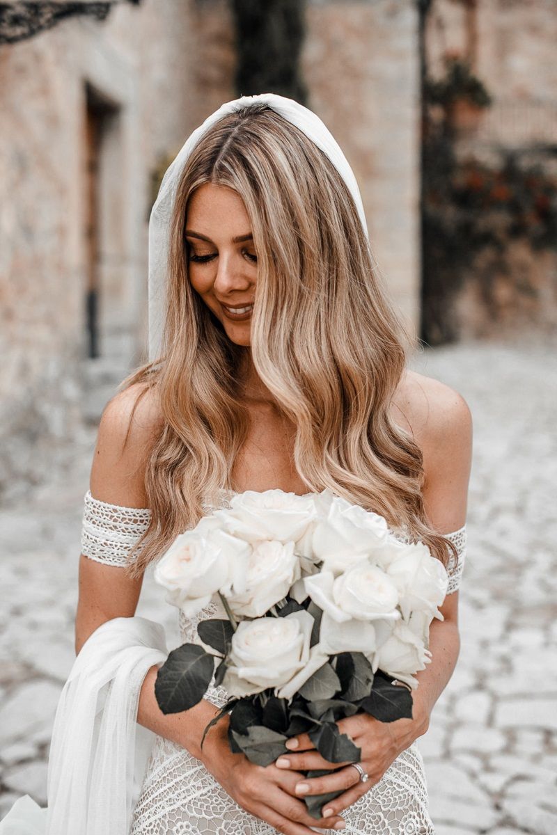 Noiva de costas, com penteado para noiva solto, véu e tiara delicada