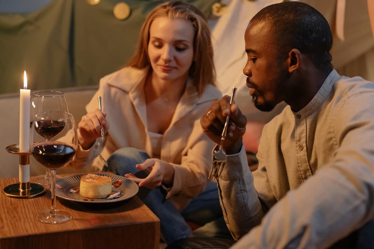 Casal em um restaurante jantando com velas e vinho