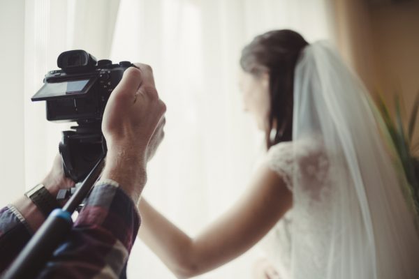 |Casal sendo fotografado por um homem|Casal dançando durante o casamento|Casamento na igreja|Casal se beijando enquanto pousam para a câmera|Casal em um ambiente romântico para foto|Casal dançando durante a festa|Homem fazendo filmagens||||